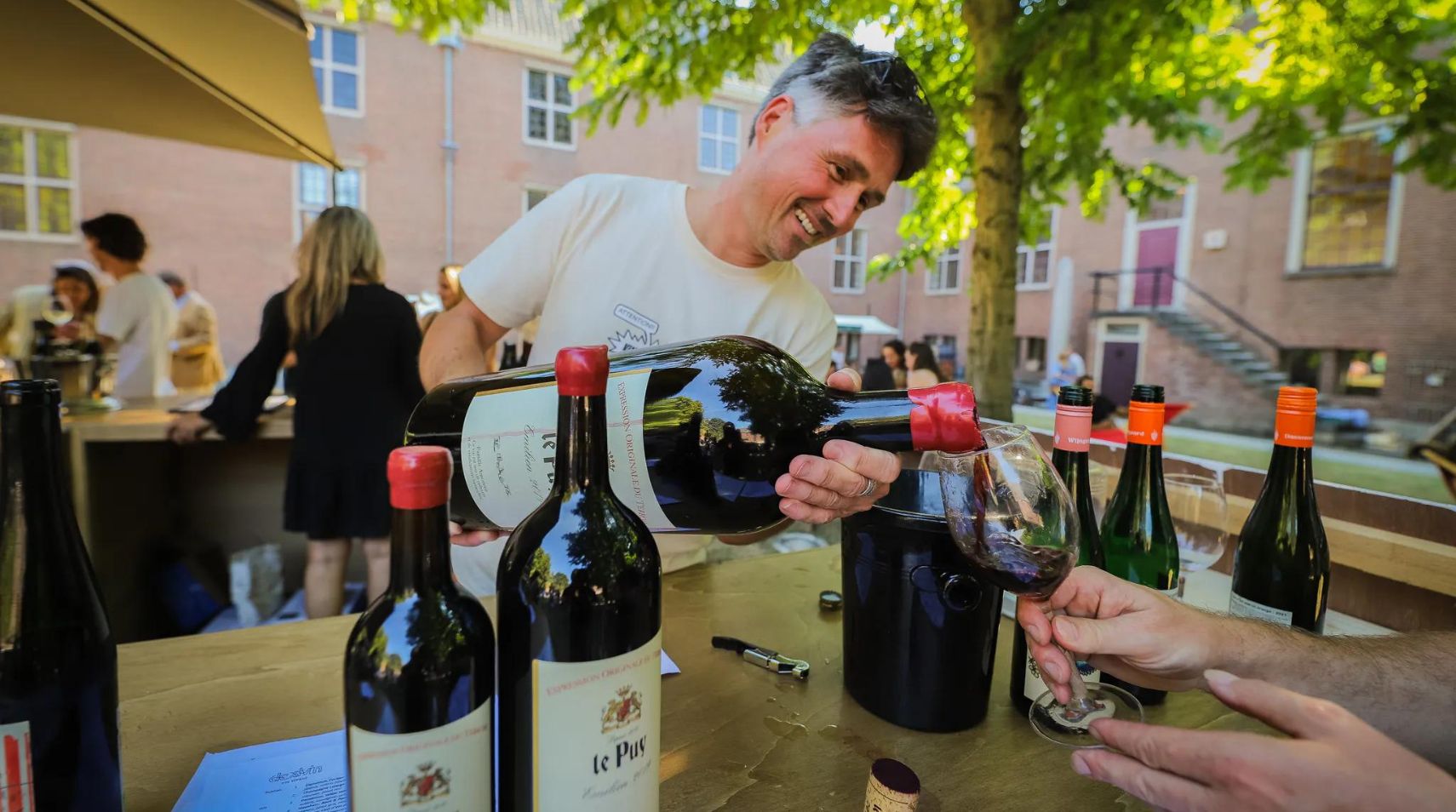 Man schenkt grote fles wijn in